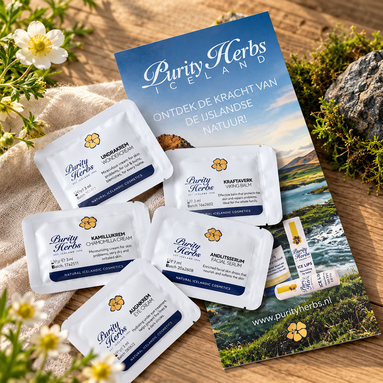 Purity Herbs proefpakket met vijf verzorgingssamples en een informatiebrochure, op een natuurlijke achtergrond met bloemen en hout.