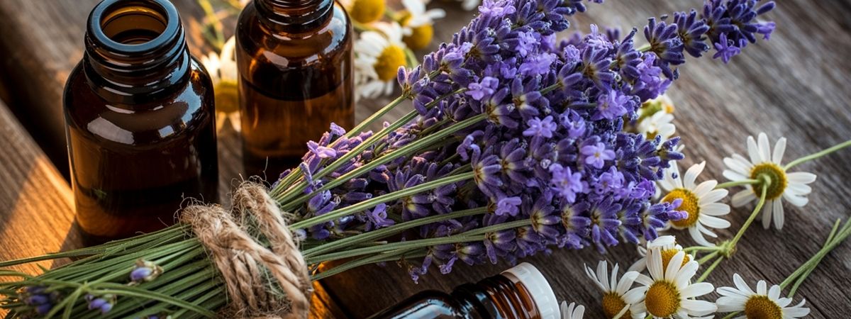 Lavendel en kamilleachtige bloemen met bruine flesjes etherische olie voor natuurlijke huidverzorging.